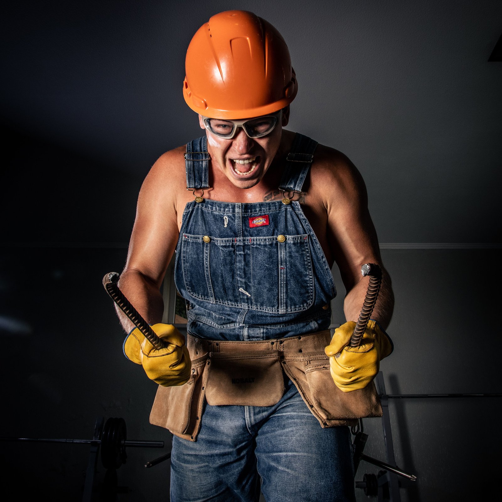 Portrait of a construction worker in protective gear, energetically engaged in work with tools.